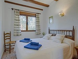 a bedroom with a bed with two blue towels on it at Holiday Home La Concha by Interhome in Balcon del Mar +30 photos