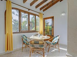 a dining room with a table and chairs and windows at Holiday Home La Concha by Interhome in Balcon del Mar