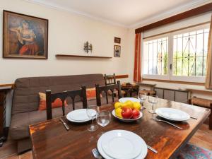 a dining room with a table and a couch at Apartment Anfora 2 by Interhome in Sant Martí d'Empúries