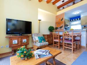 una sala de estar con un televisor y una mesa en Apartment Residencial Gran Sol by Interhome, en L'Escala