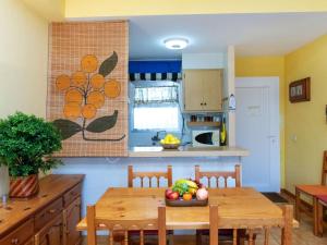 Una cocina con una mesa con un bol de fruta encima. en Apartment Residencial Gran Sol by Interhome, en L'Escala