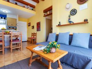 Una sala de estar con un sofá azul y una mesa. en Apartment Residencial Gran Sol by Interhome, en L'Escala 16 fotos más
