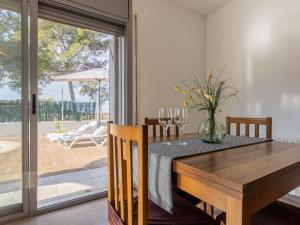 a dining room with a wooden table and a sliding glass door at Holiday Home Gaviota 15 by Interhome in Riumar +21 photos