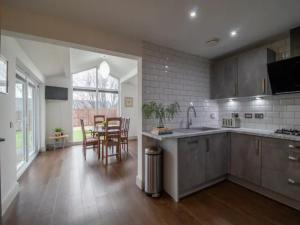 a large kitchen with a table and chairs in it at Pass the Keys Comfortable and Fabulous Family Home in Newton Mearns