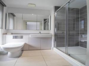 a bathroom with a toilet and a sink and a shower at Pass the Keys Comfortable and Fabulous Family Home in Newton Mearns