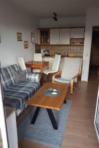 een woonkamer met een bank en een tafel bij Apartment Norderney by Interhome in Dornumersiel