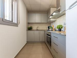 una cocina con armarios blancos y fregadero en Holiday Home Gaviota 16 by Interhome, en Riumar