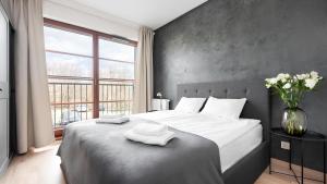 a bedroom with a large bed with two towels on it at Flatbook - City Center SPA Apartments A,B,C in Gdańsk