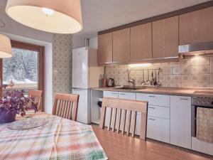 uma cozinha com uma mesa e cadeiras e um frigorífico em Holiday Home Wiese by Interhome em Oberlehn