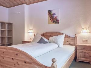 Schlafzimmer mit einem Holzbett mit einem Kopfteil aus Holz in der Unterkunft Holiday Home Wiese by Interhome in Oberlehn