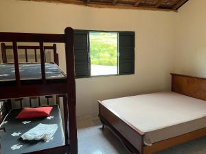 巴黑羅聖荷西的住宿－Casa na roça，一间卧室设有两张双层床和一扇窗户。
