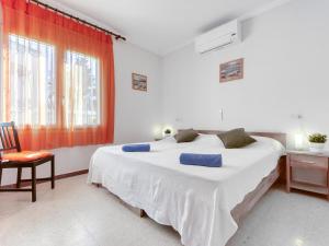 エンプリアブラバにあるHoliday Home Requesens by Interhomeのベッドルーム(大きな白いベッド1台、椅子付)