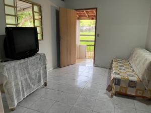 Casa na roça في ساو جوز دو باريو: غرفة معيشة مع تلفزيون وأريكة