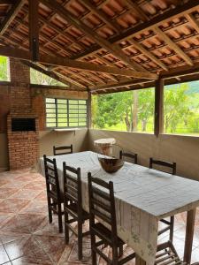 un grande tavolo con sedie in un patio con tavolo di Casa na roça a São José do Barreiro