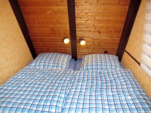 a bed in a room with a wooden ceiling at Holiday Home Winnetou by Interhome in Machtlos