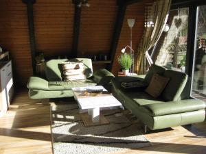 uma sala de estar com dois sofás verdes e uma mesa em Holiday Home Winnetou by Interhome em Machtlos