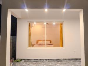 Marari Aidenz Beach Vibe Villa في أليبي: مرآة في غرفة بيضاء مع سرير فيها
