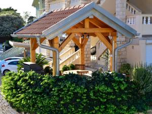 a wooden gazebo on the side of a building at Apartment Olga-5 by Interhome in Rab