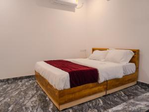 Marari Aidenz Beach Vibe Villa في أليبي: غرفة نوم بسرير مع اطار خشبي