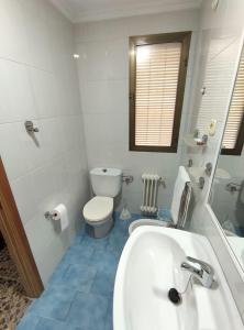 ein Badezimmer mit einem weißen Waschbecken und einem WC in der Unterkunft Hostal El Molino in Villahermosa