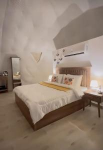 a bedroom with a large bed and a table at AVICENNIA BEACH DOMES in Salalah