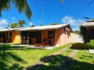 uma pequena casa com um jardim em frente em Chalés Coco Verde - Praia de Itacimirim em Itacimirim