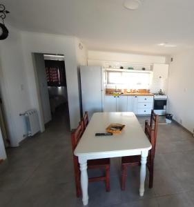 - une cuisine avec une table et des chaises blanches dans la chambre dans l'établissement La Casita en Tandil, à Tandil