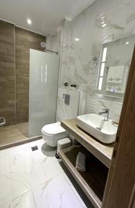 a bathroom with a toilet and a sink and a shower at Navarino Luxe Suites with Sea View in Perea