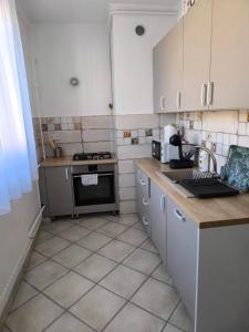a kitchen with white cabinets and a stove top oven at City Heaven Apartment in Szeged