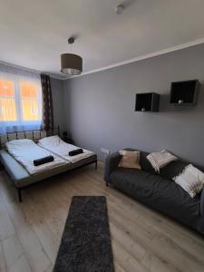 a living room with a bed and a couch at City Heaven Apartment in Szeged