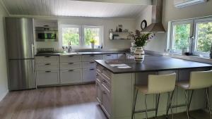 cocina con nevera y barra con sillas en La Casa Valtersson en Oskarshamn