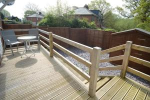 a wooden deck with a table and a fence at Refurbished House Long Stay Welcome Free Parking in Southampton