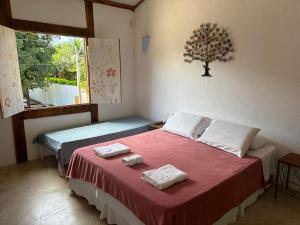 a bedroom with a bed with two towels on it at Vila Cizinho in Itaúnas