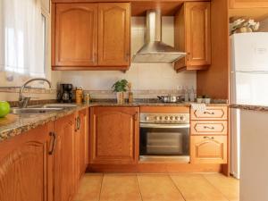 cocina con armarios de madera y horno de acero inoxidable en Holiday Home Teresa by Interhome, en Riumar
