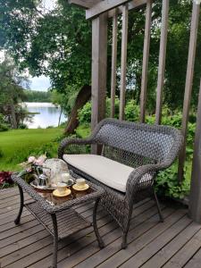 a wicker chair and a table on a deck at Ruustinnan telttamajoitukset in Saarijärvi