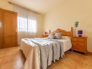 sypialnia z łóżkiem, komodą i oknem w obiekcie Holiday Home Teresa by Interhome w mieście Riumar