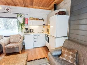 uma cozinha com um frigorífico, um sofá e uma mesa em Holiday Home Mustalampi 4 kyyhkynen by Interhome em Ruka