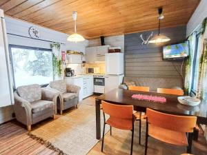 uma cozinha e sala de estar com mesa e cadeiras em Holiday Home Mustalampi 4 kyyhkynen by Interhome em Ruka