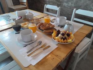 uma mesa de madeira com alimentos para o pequeno-almoço e sumo de laranja em Ríos que nos unen em Colónia do Sacramento