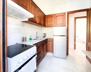 a kitchen with wooden cabinets and a white stove top oven at Malakassis House in Lefkada