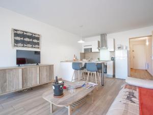 a kitchen and living room with a couch and a table at Apartment Les Louvans-2 by Interhome in Saint-Aygulf