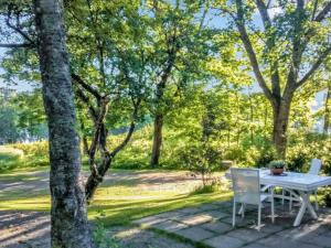 a table and chairs on a patio with trees at Holiday Home Isopehtoori by Interhome in Hirsjärvi