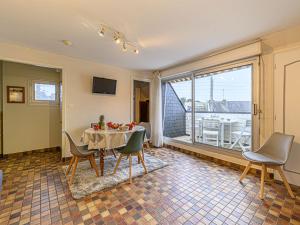 d'une salle à manger avec une table, des chaises et une fenêtre. dans l'établissement Apartment Les Embruns-1 by Interhome, à Carnac