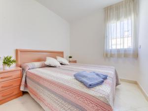 a bedroom with a bed with a blue towel on it at Apartment Puigmal by Interhome in Empuriabrava