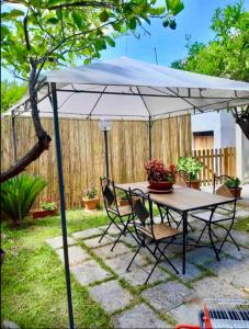 a table and chairs under an umbrella in a yard at The Green House Bed & Breakfast in Serrano