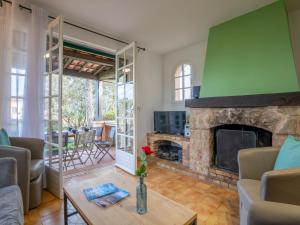 a living room with a fireplace and a table at Villa La Galandière by Interhome in Saint-Aygulf