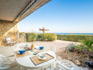 a patio with a table and chairs and the ocean at Apartment Maures de l'Esterel-1 by Interhome in Saint-Aygulf