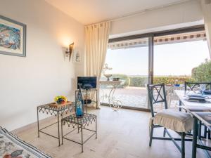 a living room with a table and chairs and a balcony at Apartment Maures de l'Esterel-1 by Interhome in Saint-Aygulf