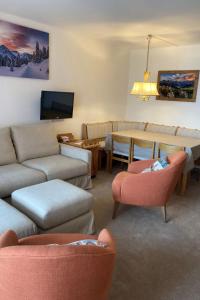 ein Wohnzimmer mit einem Sofa, einem Tisch und Stühlen in der Unterkunft Apartment Promenade - Utoring-79 by Interhome in Arosa