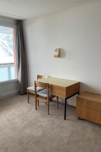 アローザにあるApartment Promenade - Utoring-79 by Interhomeのデスク、椅子、窓が備わる客室です。